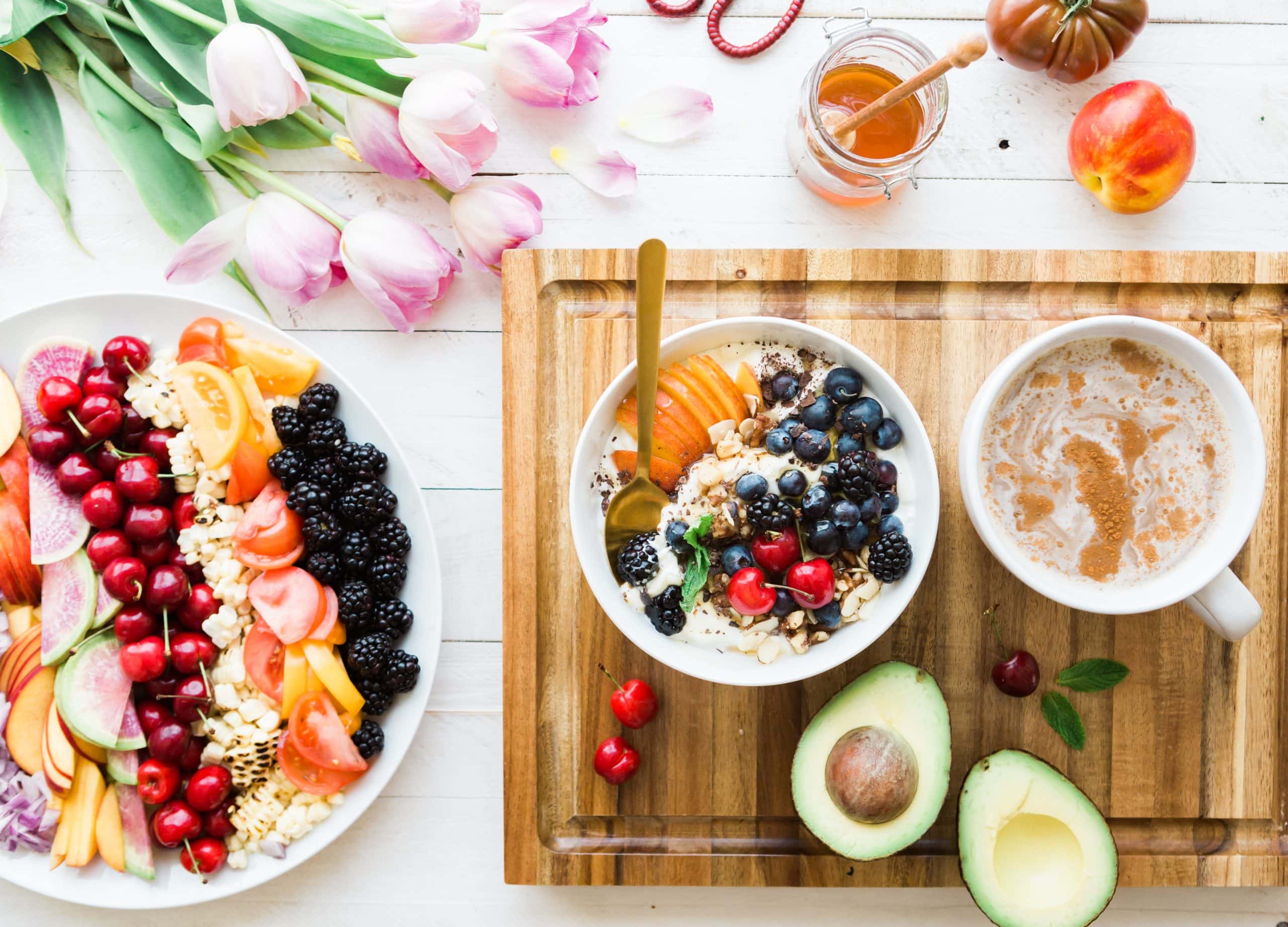 A wooden board with bowls of fruit