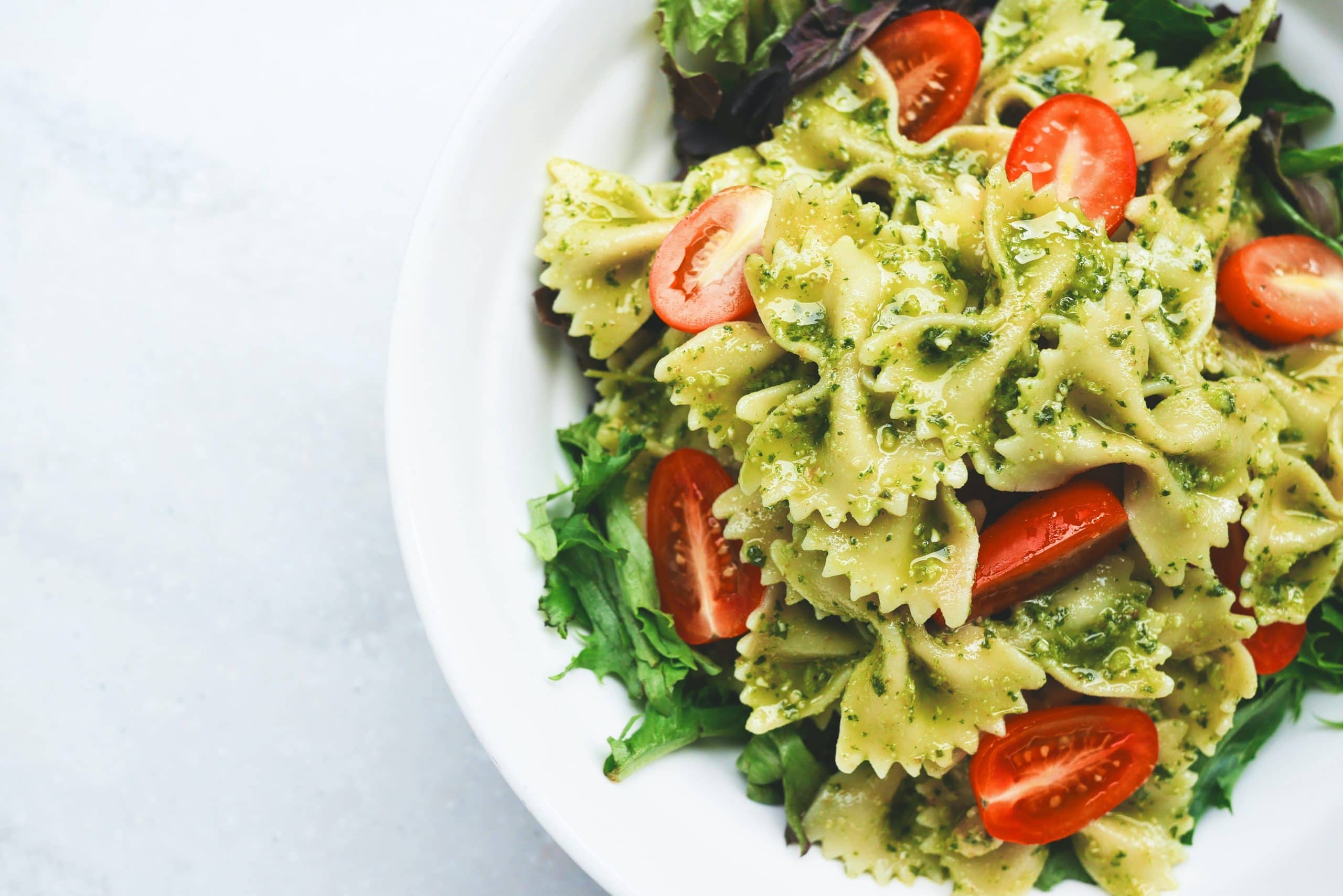 A white plate filled with pasta and salad