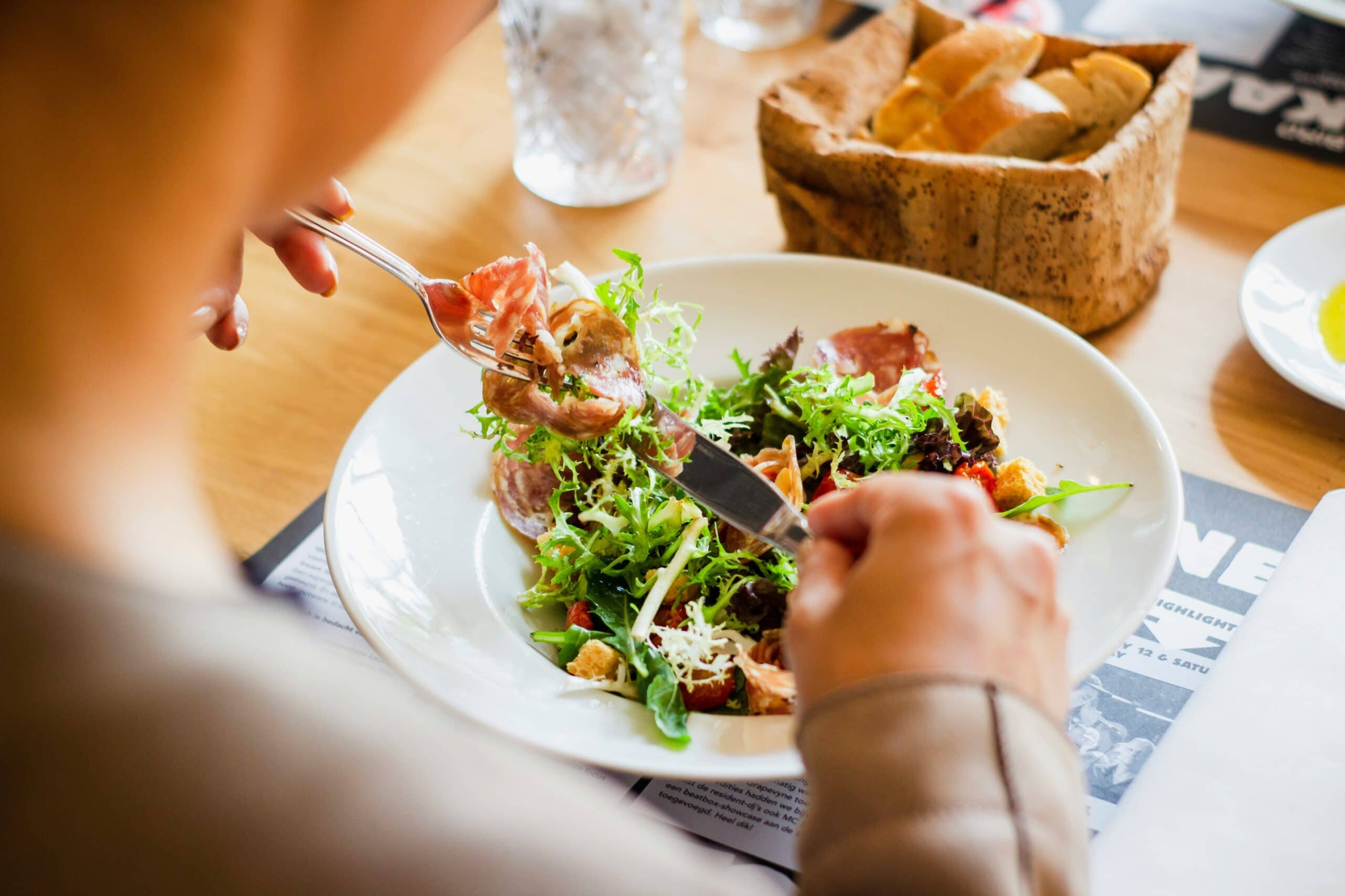 Close up of a person eating a plate of colourful salad